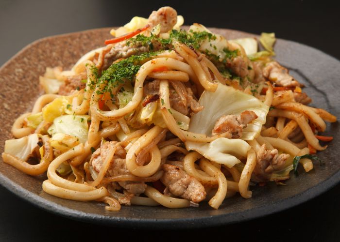 A serving of yaki udon, with stir-fried udon, meat and cabbage.